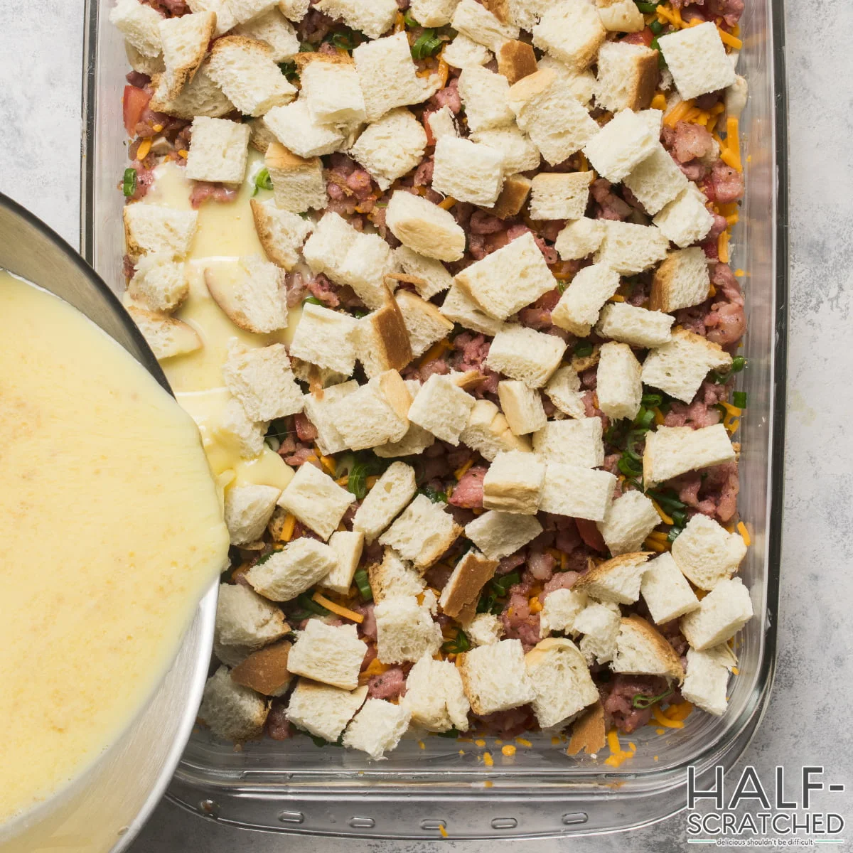 Pouring an egg mixture into sausage breakfast recipe