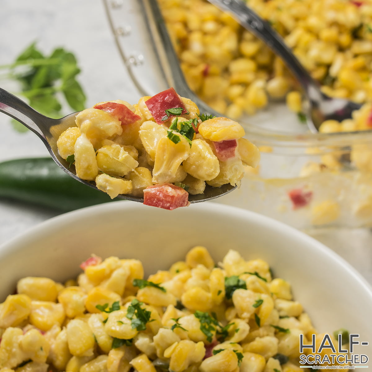 Spoonful of corn casserole showing creamy texture and red bell peppers