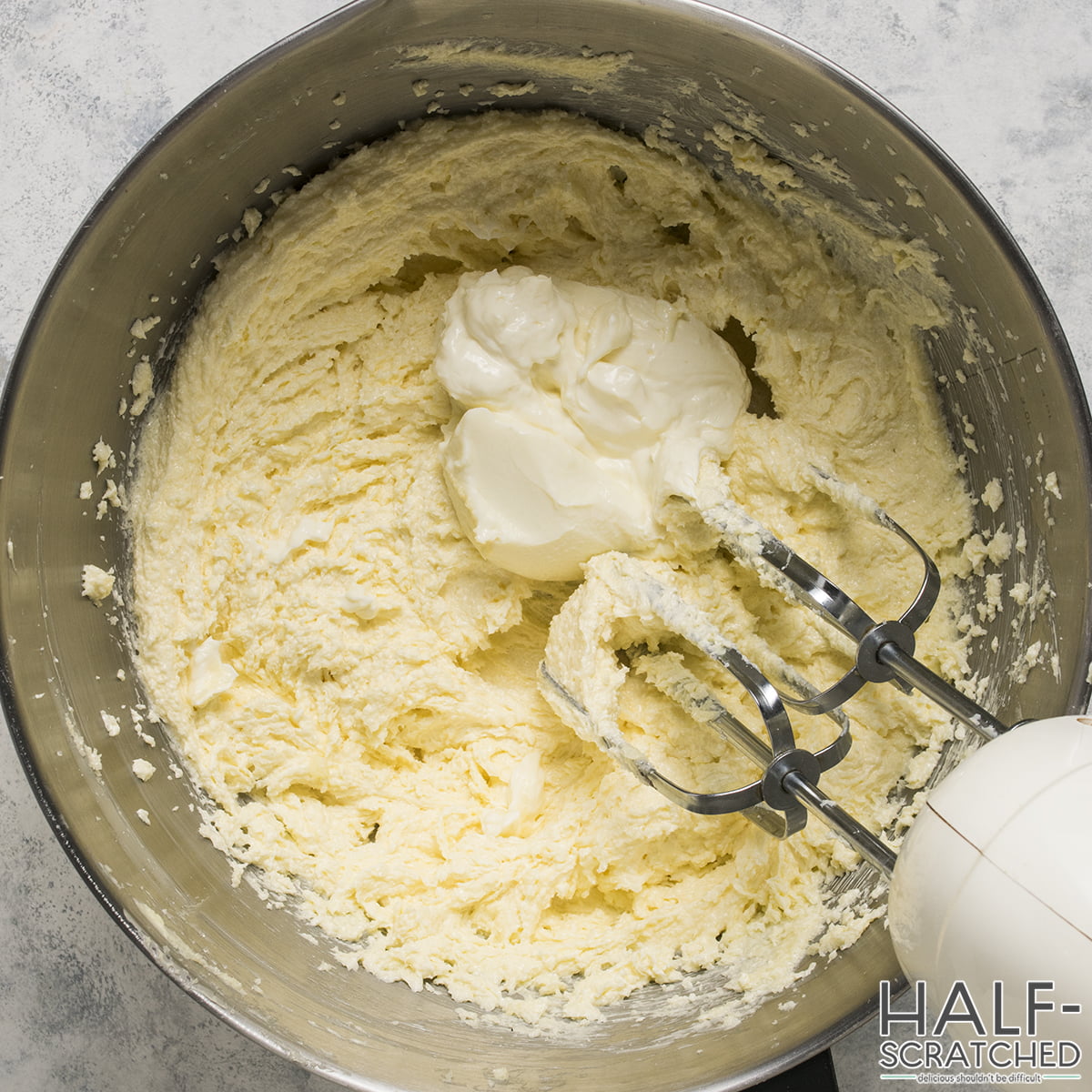Adding cream cheese to a mixture of butter and sugar
