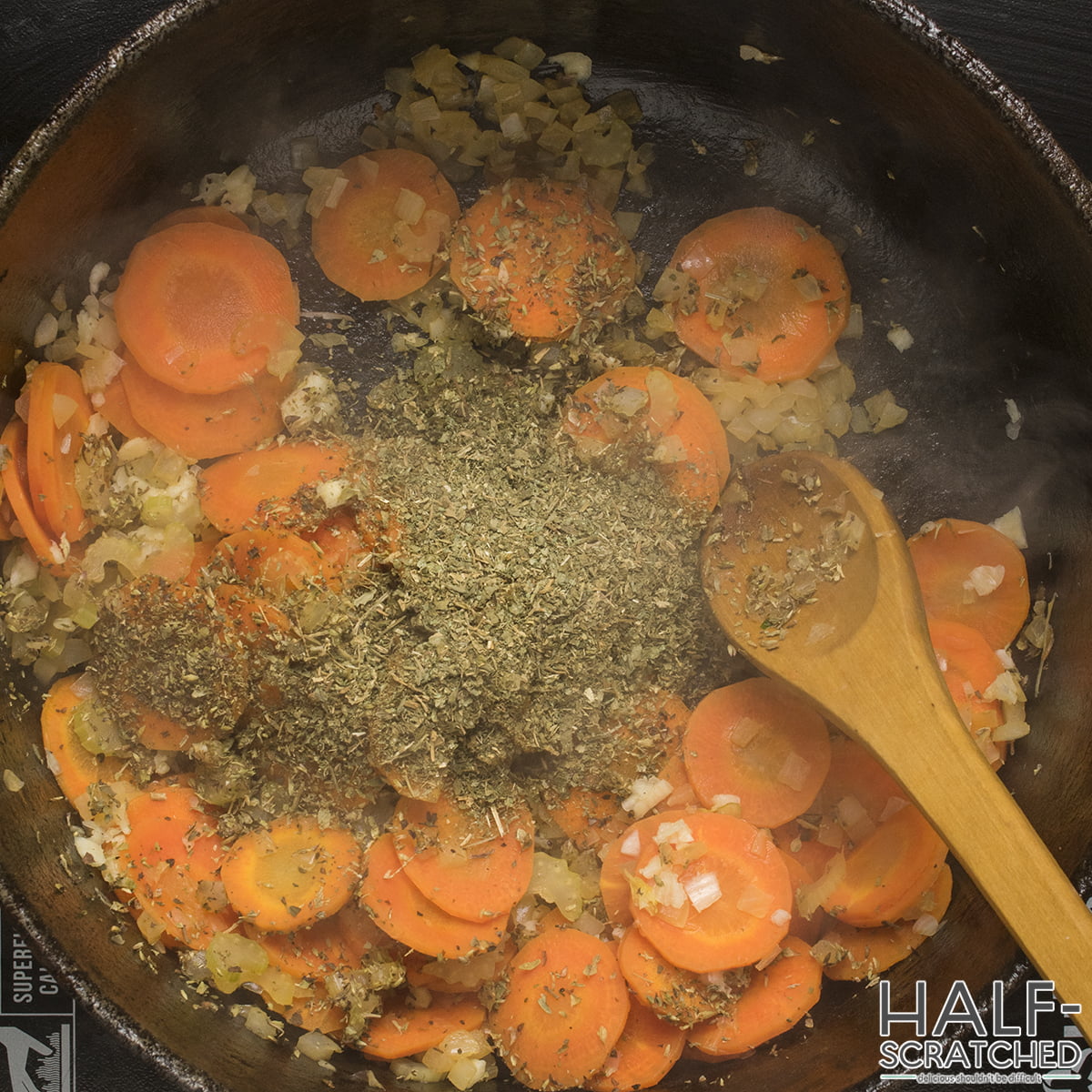 Adding seasoning to the sautéed carrots and onions