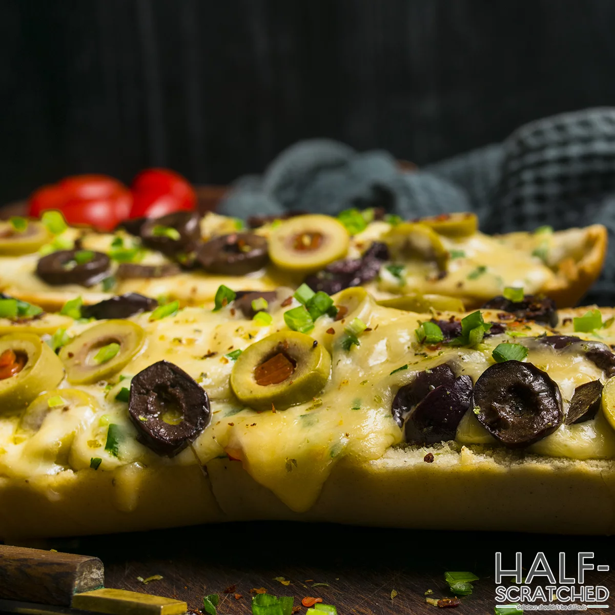 Close view of olive bread with melted cheese and olives"