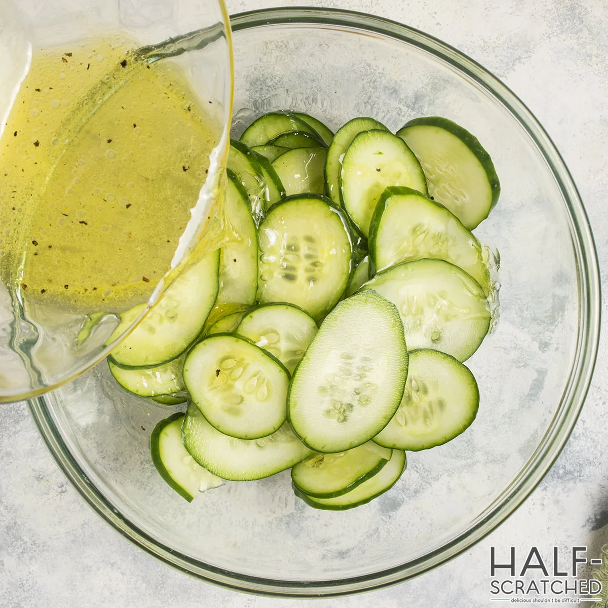 Pouring vinaigrette over cucumber slices