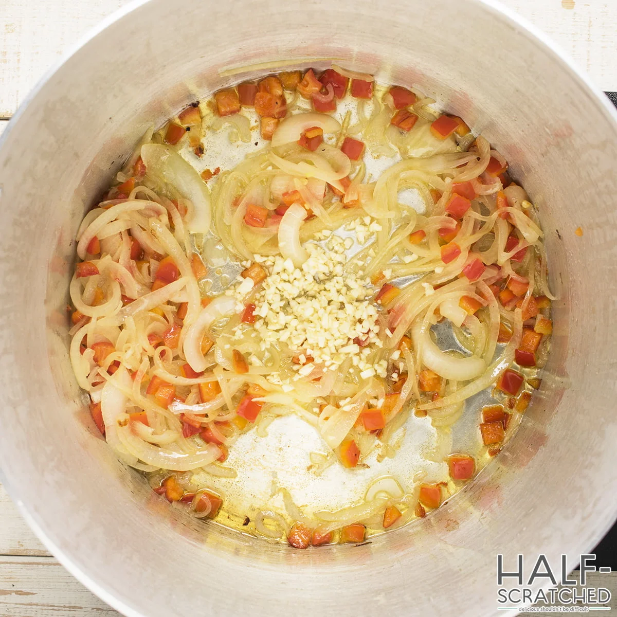 Sautéed onions and red bell peppers in a pot