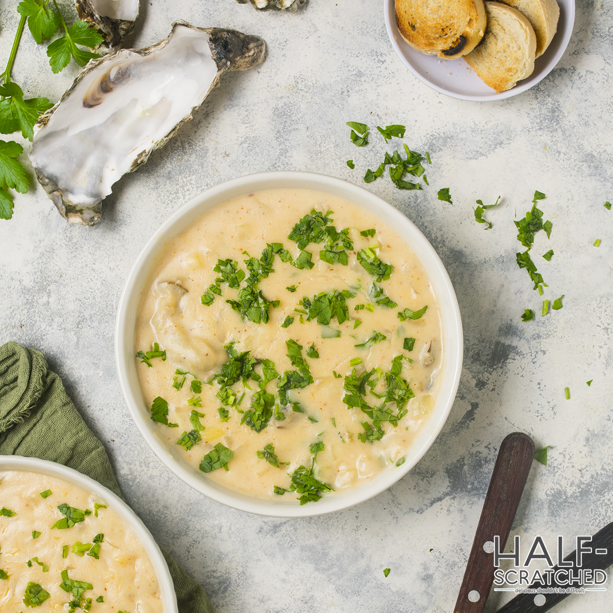 Top view of oyster stew with parsley and bread